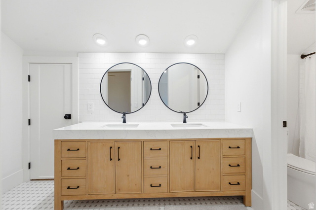 3027 Homestead Road Park City, UT 84098 - Photo 37 of 62 Dual vanity featuring natural wood cabinetry, white countertop, and two round black-framed mirrors