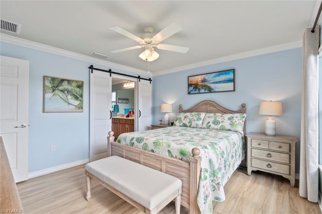 5796 Declaration Court Ave Maria, FL 34142 - Photo 18 of 49 a bedroom with a bed and a chandelier