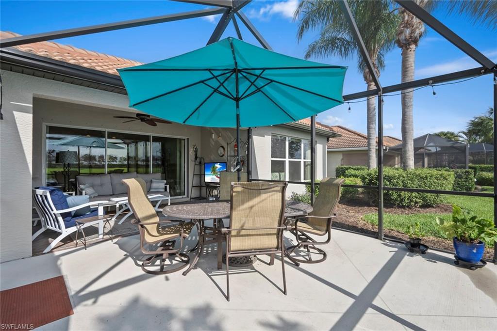 5796 Declaration Court Ave Maria, FL 34142 - Photo 26 of 49 a view of patio with chairs and table under an umbrella