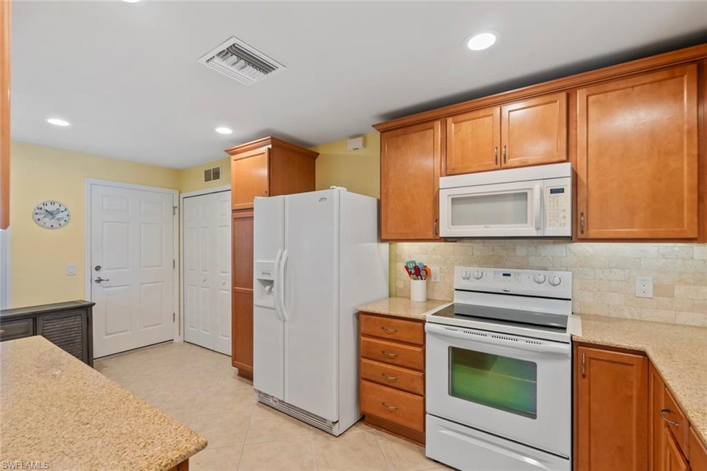 5796 Declaration Court Ave Maria, FL 34142 - Photo 8 of 49 a kitchen with a refrigerator a stove top oven and cabinets