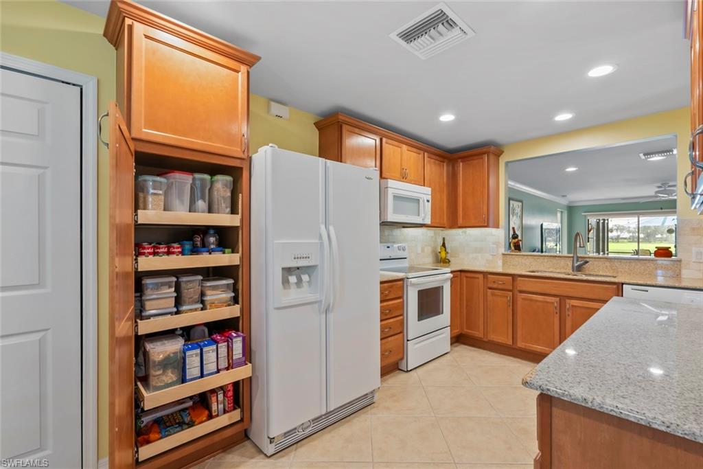 5796 Declaration Court Ave Maria, FL 34142 - Photo 10 of 49 a kitchen with stainless steel appliances granite countertop a refrigerator and a sink