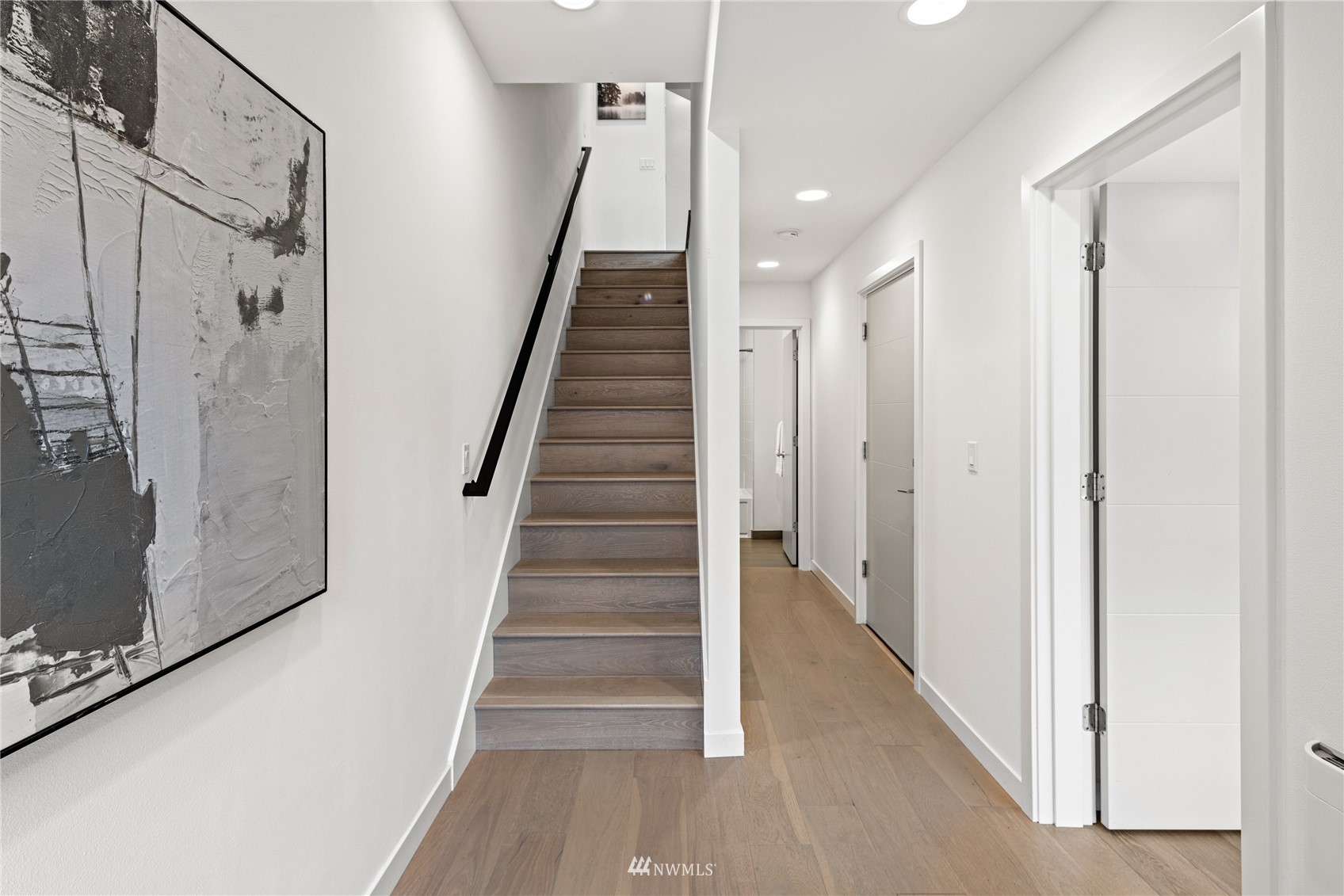 4205 Southwest Frontenac Street Seattle, WA 98136 - Photo 6 of 39 a view of staircase with lots of frames on wall and wooden floor