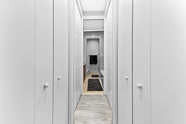 a view of a hallway with wooden shelves