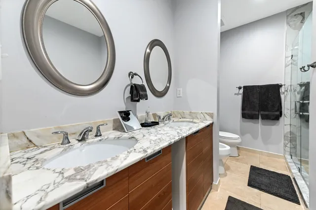 a bathroom with a granite countertop sink a toilet and a mirror