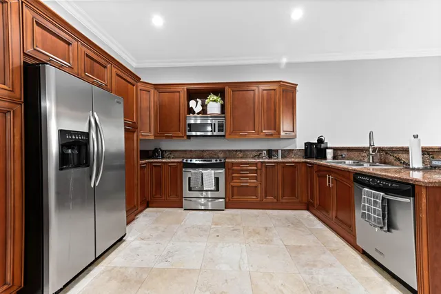 a kitchen with stainless steel appliances granite countertop a stove a sink and a refrigerator