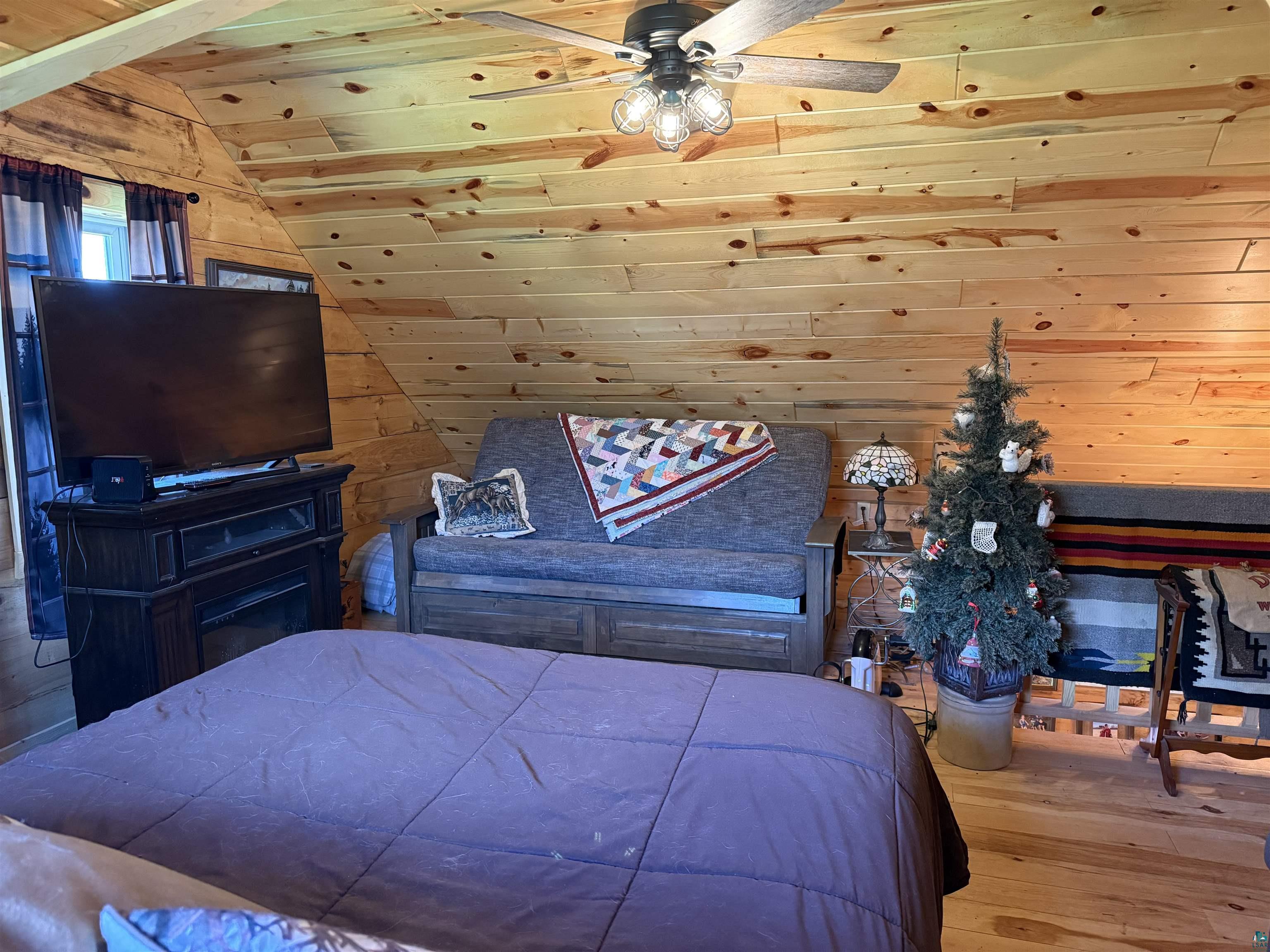 37590 Degerstrom Road Askov, MN 55704 - Photo 25 of 53 Wood-paneled room featuring sloped ceilings and wood-finish flooring
