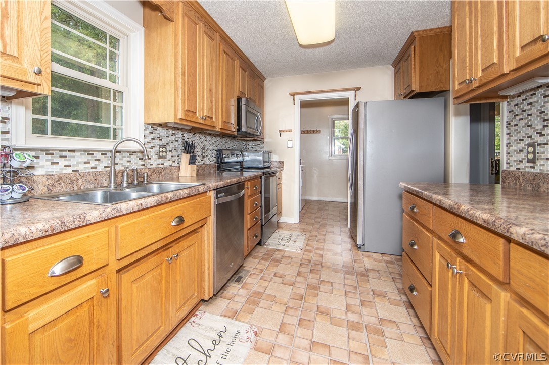 5605 Allin Road Prince George, VA 23875 - Photo 7 of 19 The kitchen offers natural-stained cabinets, mosaic backsplash and stainless appliances.