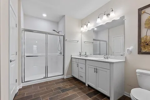 a bathroom with a double vanity sink mirror and toilet
