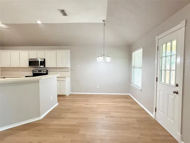 a kitchen with granite countertop white cabinets and stainless steel appliances