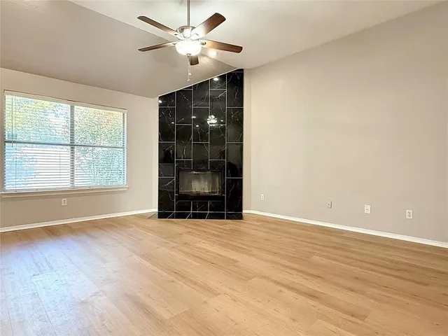 an empty room with windows and ceiling fan
