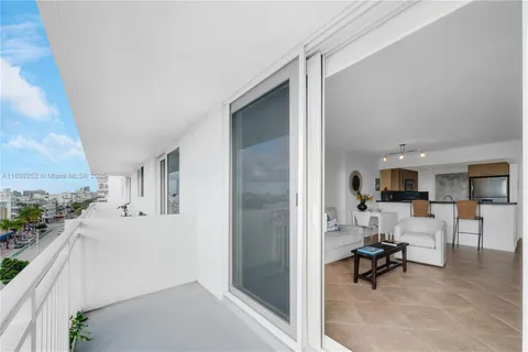a living room with furniture a flat screen tv and kitchen view