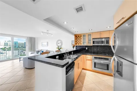 a kitchen with granite countertop a sink and white cabinets