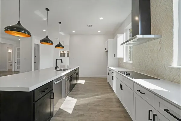 a large kitchen with granite countertop a sink and a refrigerator