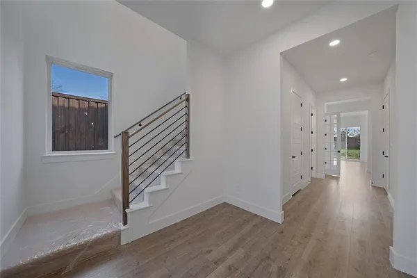 a view of a hallway with wooden floor and stairs