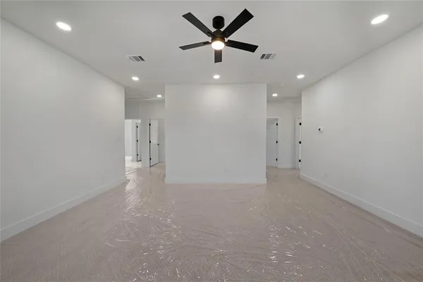 an empty room with closet and a ceiling fan