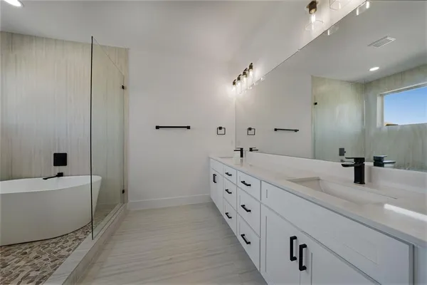 a bathroom with a double vanity sink and mirror with shower