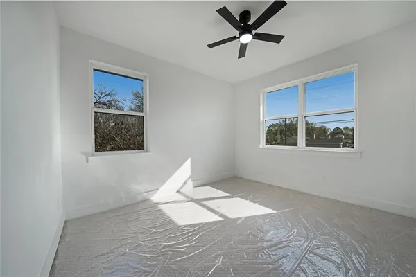 a view of a big room with wooden floor and windows