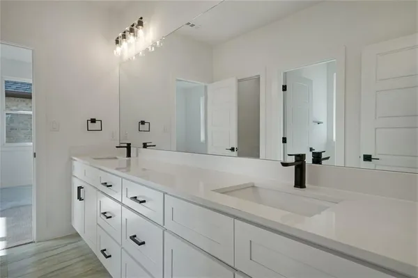 a bathroom with double vanity sink and a mirror