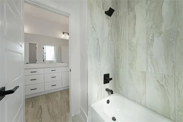 a bathroom with a bathtub a sink a vanity and a shower