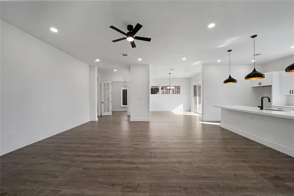 a view of a living room a ceiling fan and kitchen view