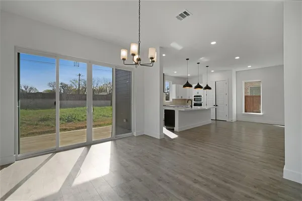a view of a kitchen with refrigerator and wooden floor