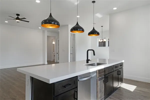 a kitchen with stainless steel appliances granite countertop a sink a stove and a wooden floors