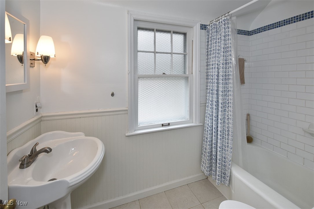 2469 Queenston Road Cleveland, OH 44118 - Photo 23 of 37 Full bathroom featuring tile patterned flooring, a wainscoted wall, shower / tub combo with curtain, and a sink