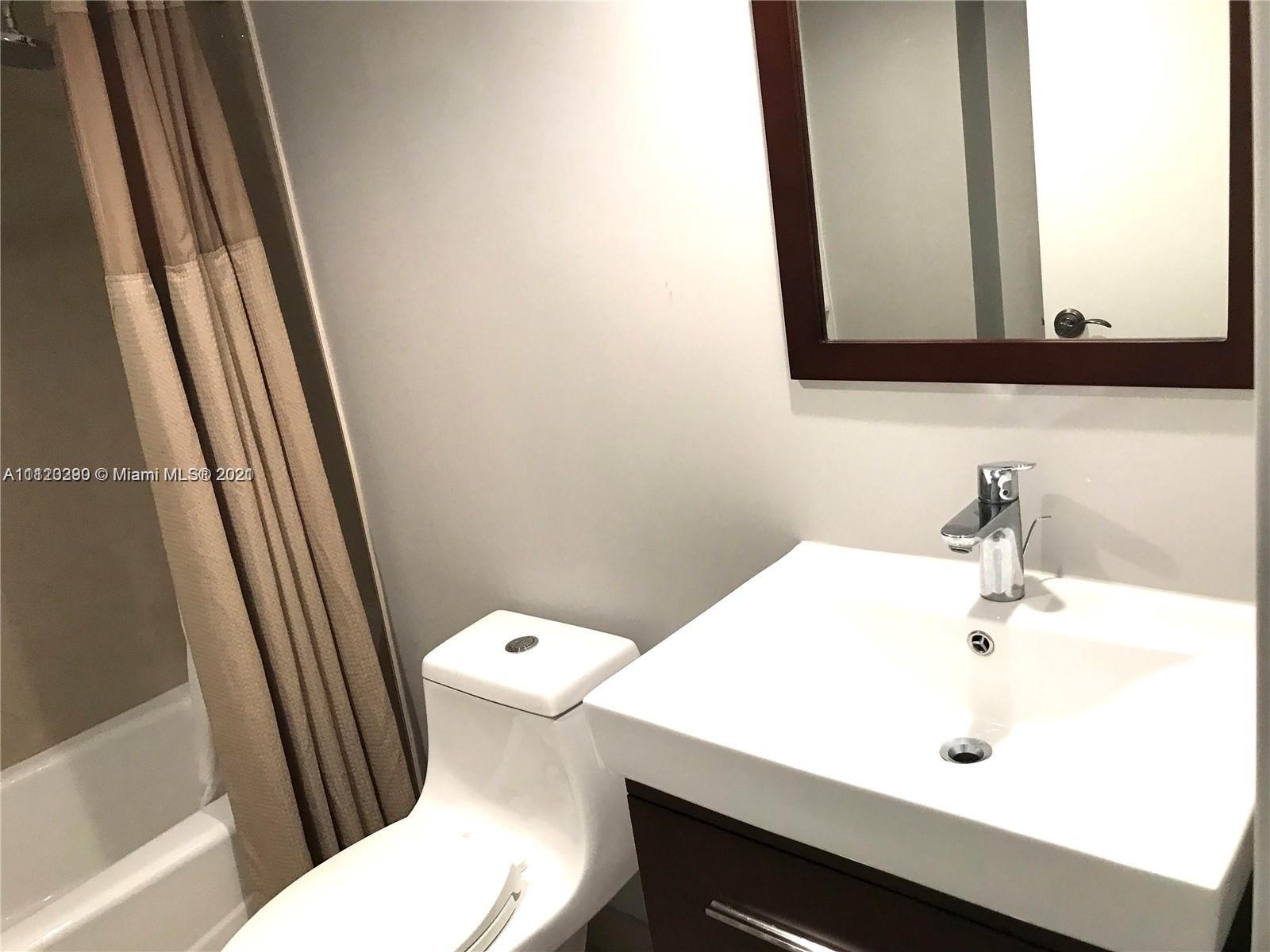 520 Brickell Key Drive, Unit A1717 Miami, FL 33131 - Photo 4 of 6 a bathroom with a sink a toilet and a mirror
