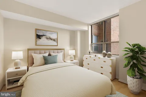 a bedroom with bed and large windows