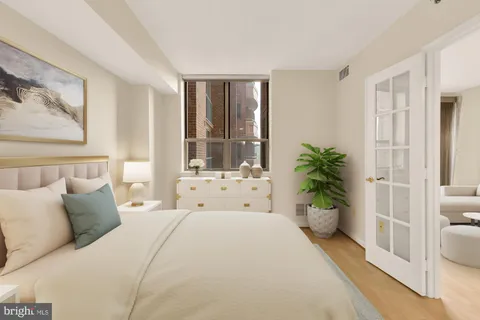 a spacious bedroom with a large bed and a potted plant