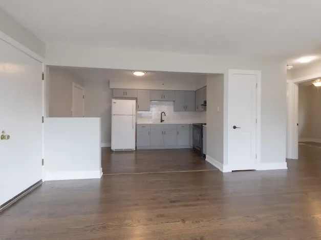 a view of a kitchen with wooden floor and a sink