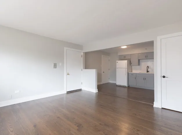 a view of empty room with wooden floor
