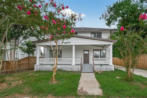 a front view of a house with a yard and a garden