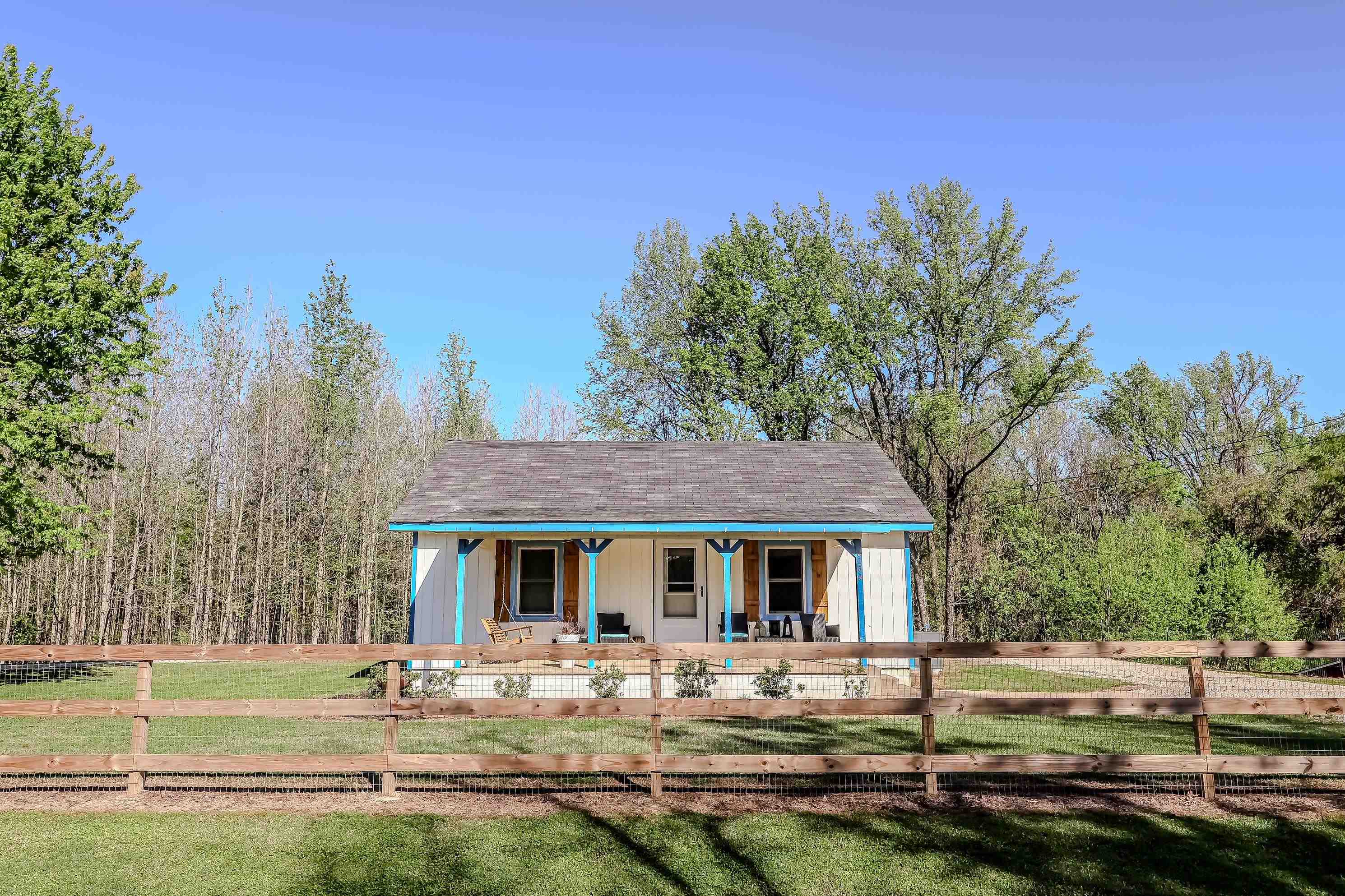 6264 Asbury Glimp Road Ripley, TN 38063 - Photo 1 of 18 View of front facade featuring board and batten siding, a front lawn, covered porch, and a fenced front yard