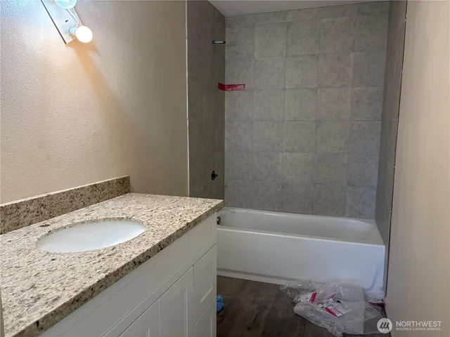 a bathroom with a granite countertop sink and a mirror