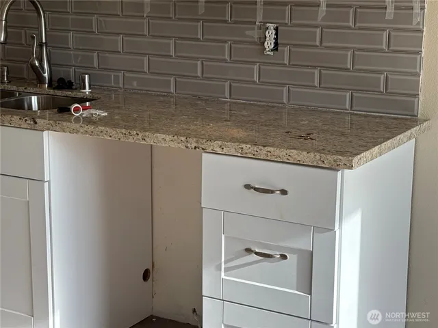 a bathroom with a granite countertop sink and a mirror