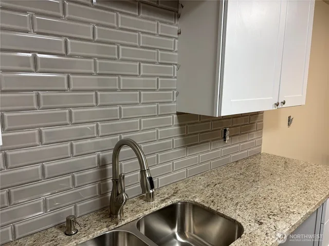 a kitchen with granite countertop white cabinets and sink