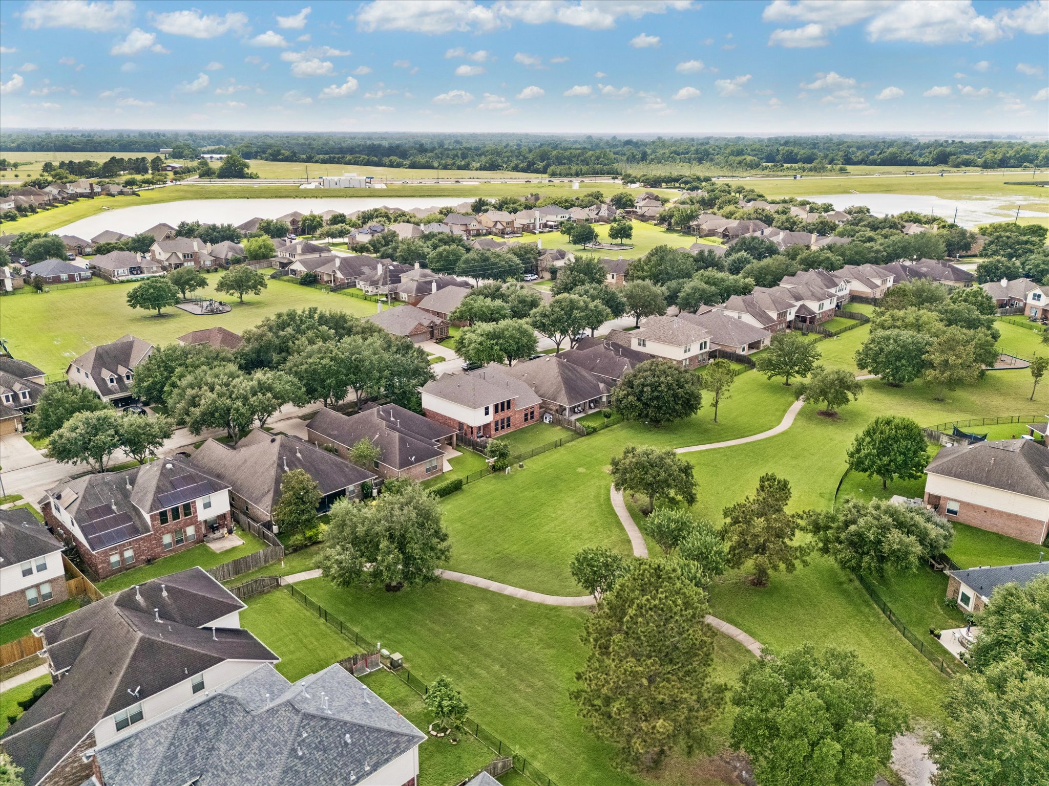 2214 Wembley Way Rosenberg, TX 77471 - Photo 35 of 35 Aerial perspective showcasing a residential community with abundant green spaces, mature trees, and a winding pathway