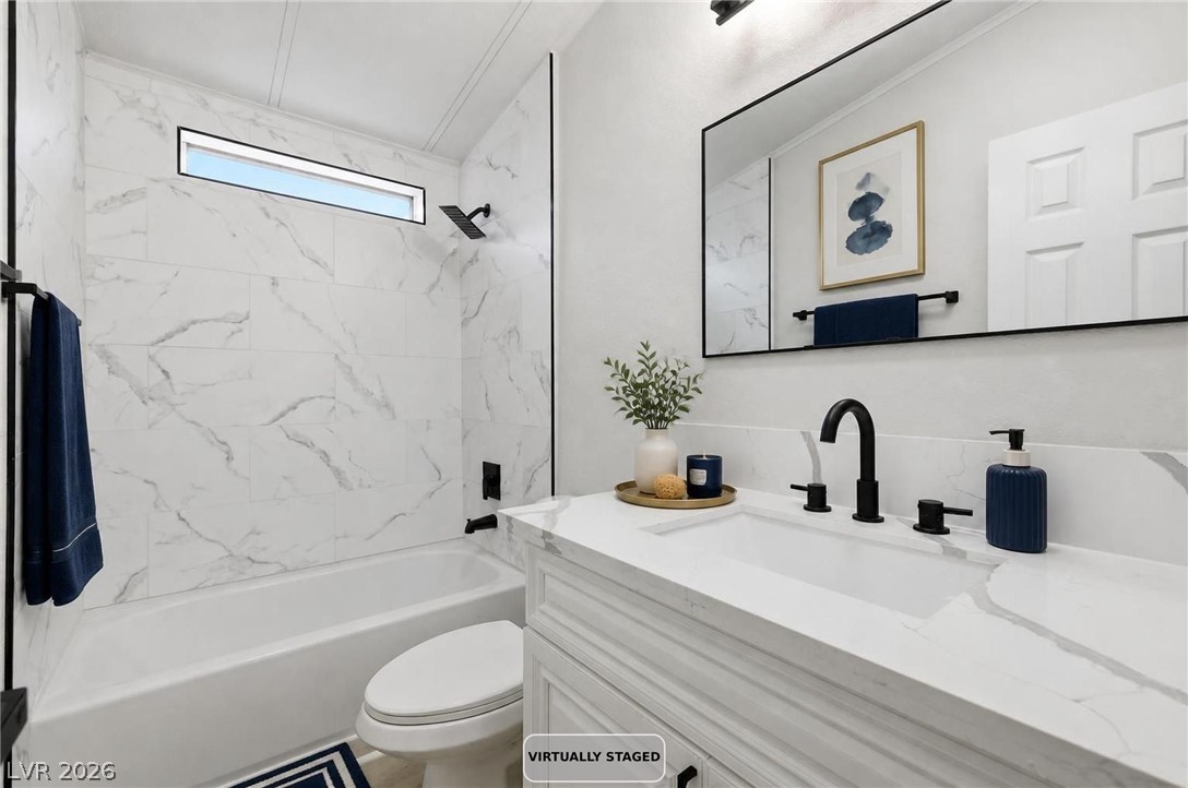 3940 Point Drive Pahrump, NV 89060 - Photo 26 of 35 Elegant white marble-patterned tile wraps this bath, creating a serene and cohesive environment.
