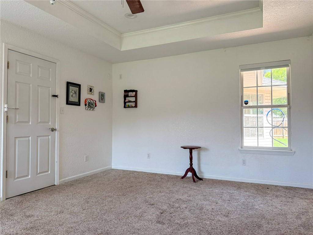 70 Walthall Road Russellville, AR 72802 - Photo 28 of 51 Primary Bedroom Carpeted room featuring a white paneled door, a single window, and a tray ceiling with a ceiling fan