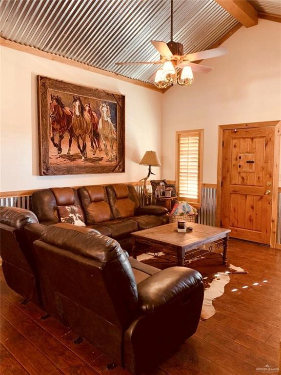 2938 Highway 83 Roma, TX 78584 - Photo 3 of 23 Living room featuring dark wood-style flooring, beam ceiling, wainscoting, high vaulted ceiling, and a ceiling fan