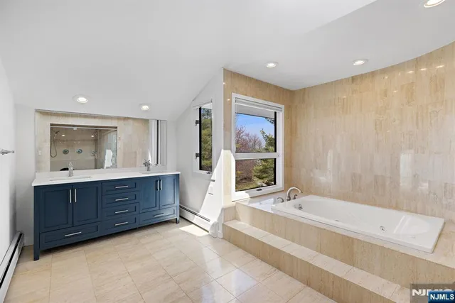 a spacious bathroom with a tub sink and mirror