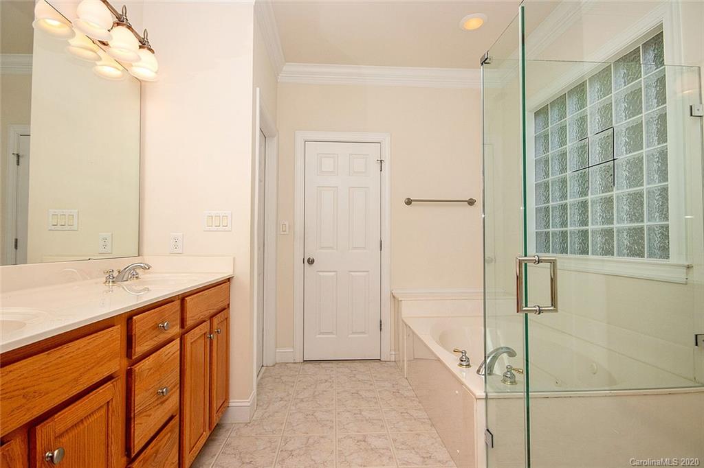644 Bracket Street, Unit 513 Fort Mill, SC 29708 - Photo 13 of 19 a bathroom with a granite countertop sink a mirror and a shower