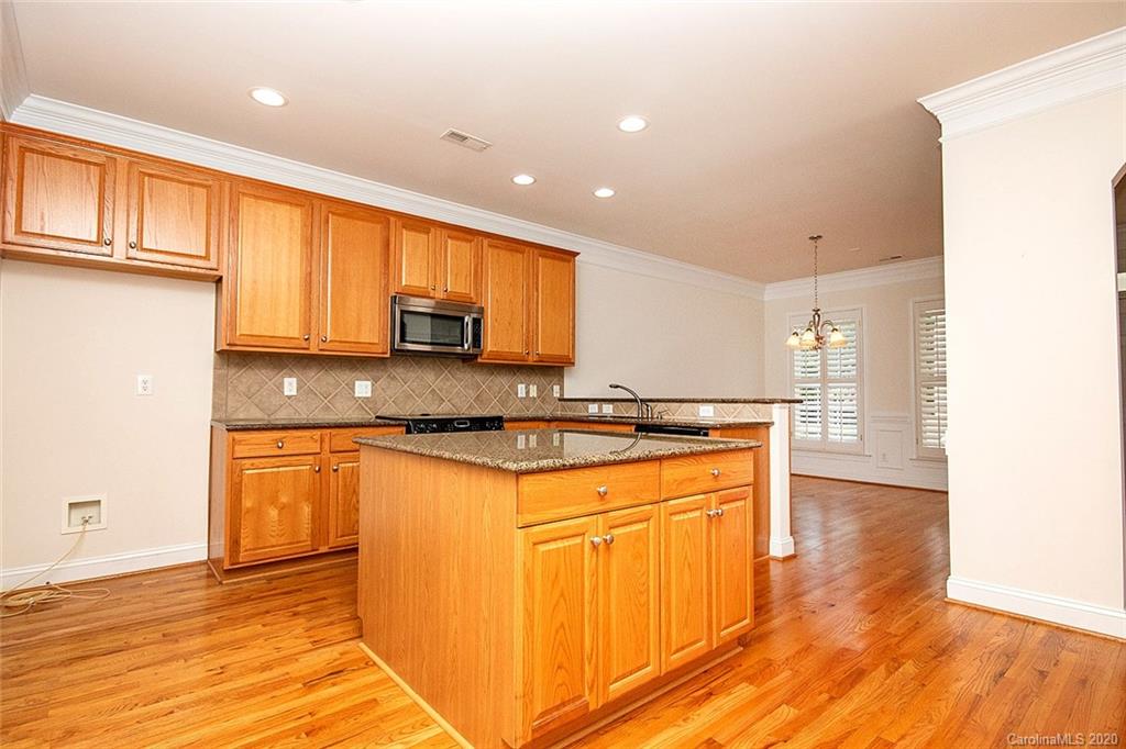 644 Bracket Street, Unit 513 Fort Mill, SC 29708 - Photo 6 of 19 a kitchen with stainless steel appliances granite countertop a stove a sink and a refrigerator with wooden floors