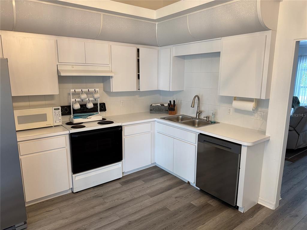 2466 Logsdon Street North Port, FL 34287 - Photo 6 of 18 a kitchen with a sink cabinets and wooden floor