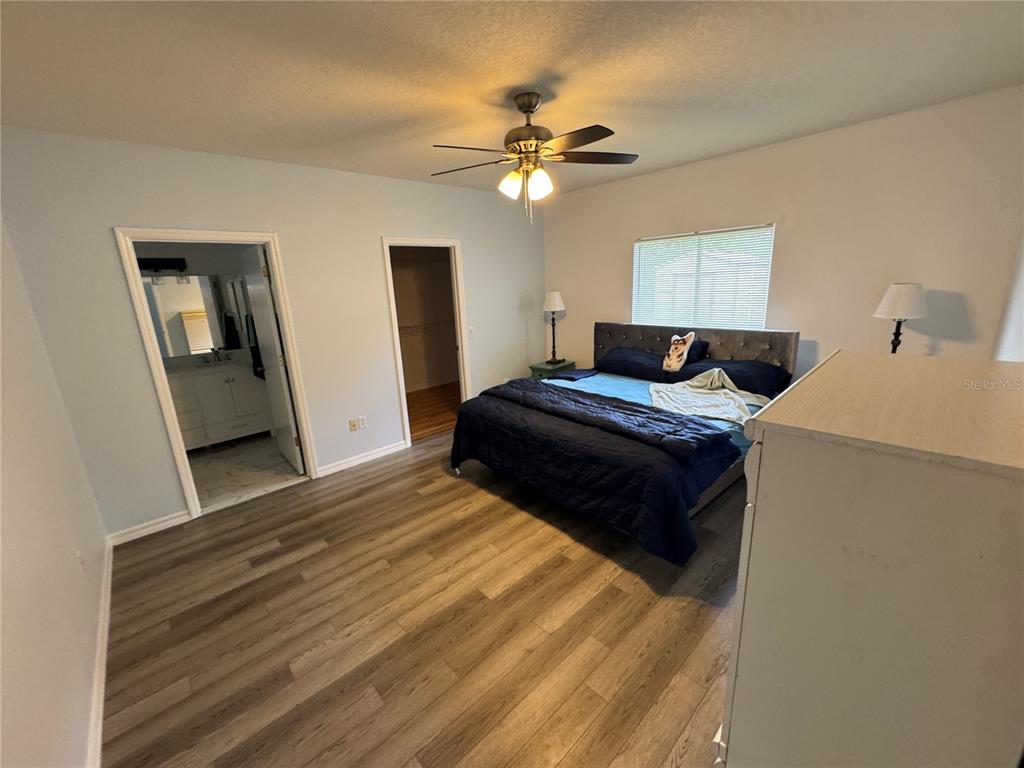 2466 Logsdon Street North Port, FL 34287 - Photo 7 of 18 a bedroom with a bed and a chandelier