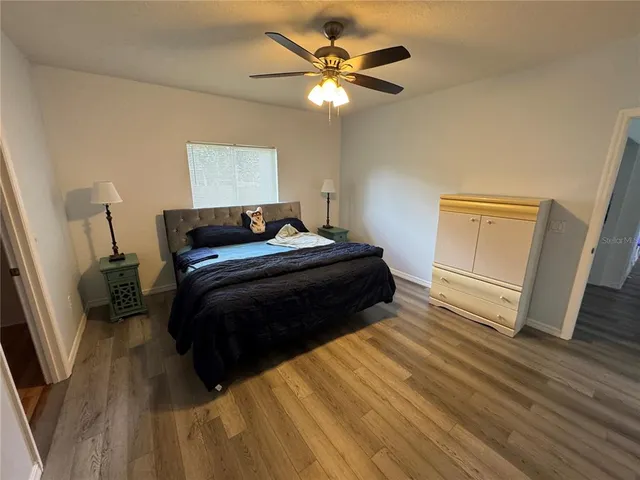 a bedroom with a bed and a ceiling fan