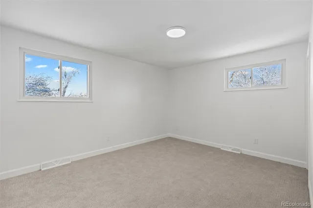 an empty room with a painting on the wall