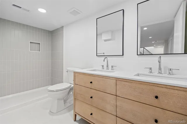 a bathroom with a toilet a sink a mirror and vanity