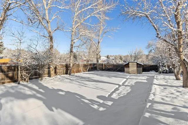 a view of residential houses with snow on the road
